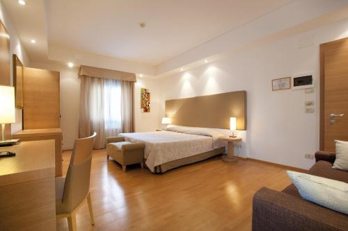 San Giovanni al NatisoneHotel Campiello的酒店客房,配有床和沙发
