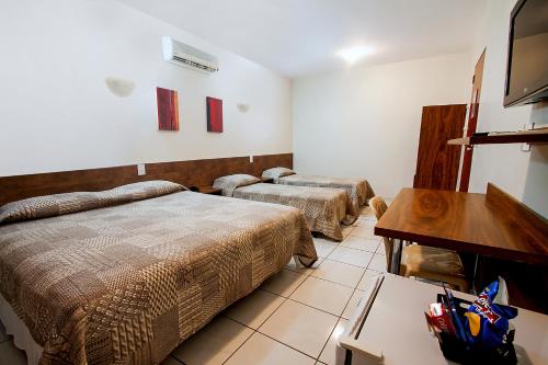 乌贝兰迪亚马拉亚酒店的客房设有两张床、一张桌子和电视。