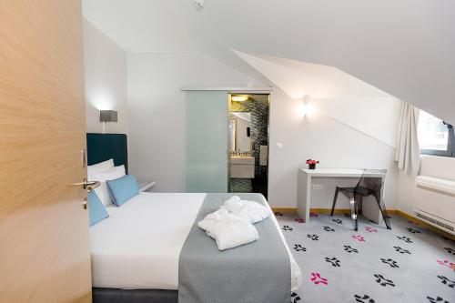 辛特拉Sintra Bliss Hotel的配有一张床和一张书桌的酒店客房