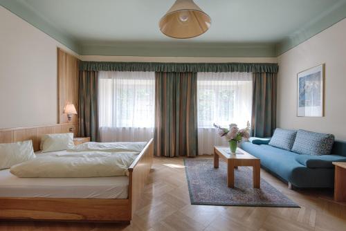 大基希海姆珀斯特酒店的一间卧室配有一张床和一张蓝色的沙发