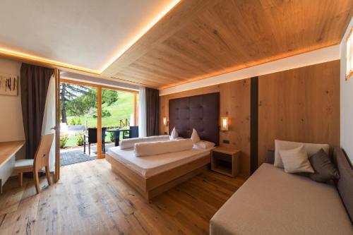 塞尔瓦迪加尔代纳山谷凡斯酒店的一间卧室配有两张床、一张桌子和一张沙发