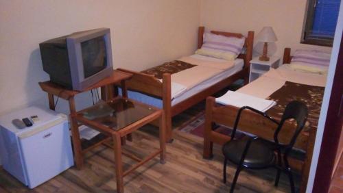 贝拉茨尔克瓦Laguna Guesthouse的小房间设有床铺和电视