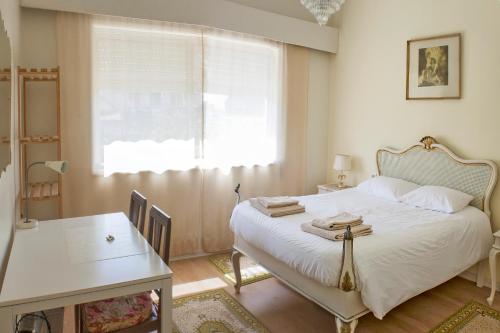 波尔图布尔戈之家度假屋的一间卧室配有一张床、一张桌子和一个窗户。
