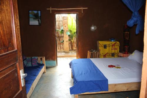 迪亚尼海滩Bahati Diani House Glamping的一间卧室配有一张床,一扇门设有窗户