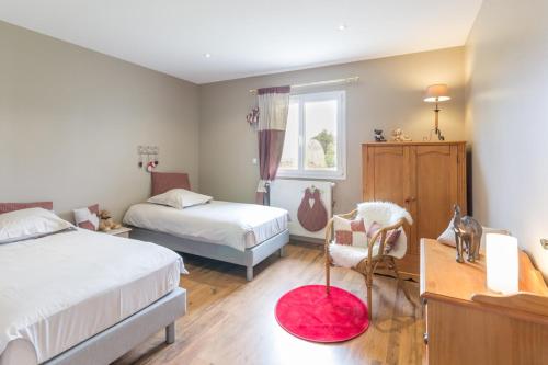 Tour-en-BessinLe Domaine de Prune的一间带两张床的卧室和红色地毯