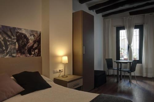 埃布罗河畔莫拉Hostal Agrobotiga 7 de Ribera的一间卧室配有一张床、一张桌子和一张桌子