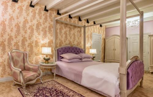 努沃勒埃利耶肯特小屋酒店的一间卧室配有一张天蓬床和一把椅子