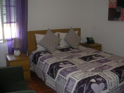 雷根古什-迪蒙萨拉什Reguengos Hotel的一间卧室配有一张床和被子