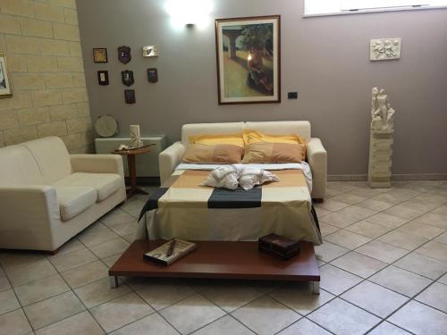 CollepassoVilla Abati的一间卧室配有一张床、一张沙发和一张桌子