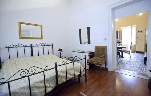 特拉帕尼Casa Signorile的一间卧室配有一张床、一张桌子和一把椅子
