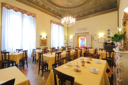 佛罗伦萨别墅利亚纳酒店的餐厅设有黄色桌椅和吊灯