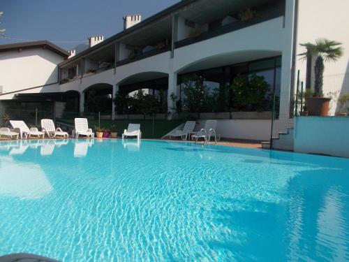 马尔切西内劳拉克里斯蒂娜酒店的一座带椅子的大型游泳池和一座建筑