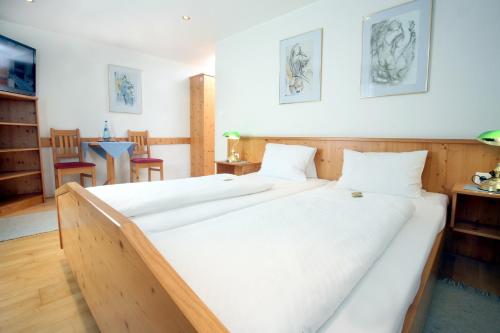 林茨甘梭夫罗瑟玛酒店的配有白色床单的客房内的两张床