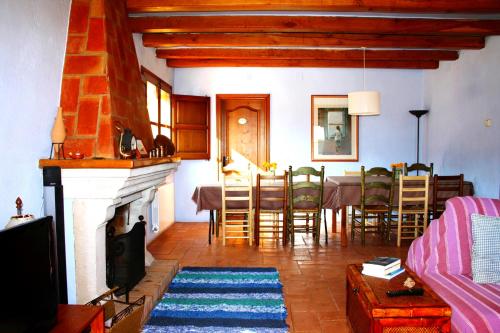 佩拉托拉达Mas Saris的客厅设有壁炉、桌子和椅子