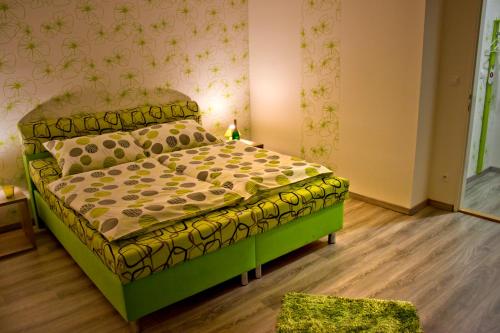 大梅杰尔Motel Görföl的一间位于客房内的带绿床的卧室