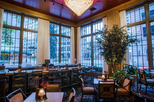 西雅图五月花公园酒店的餐厅设有桌椅和大窗户。