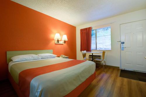 西塔科6号汽车旅馆西雅图机场店的酒店客房,配有一张橙色墙壁的床