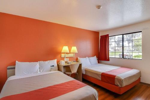 隆波克隆波克6号汽车旅馆的酒店客房设有两张床和一张带窗户的书桌。