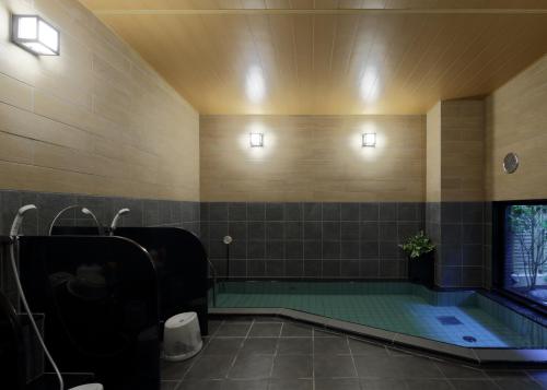日田市日田站酒店的一间带按摩浴缸和水槽的浴室