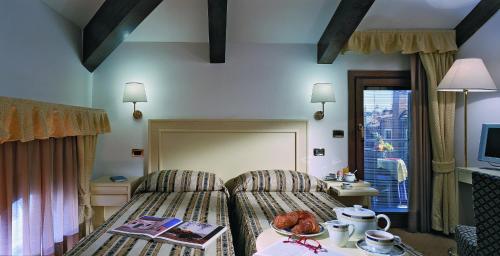威尼斯威尼斯朱代卡酒店的酒店客房设有床、桌子和窗户。
