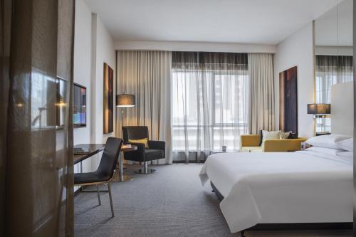 吉达沙欣吉达中心罗塔纳酒店的配有一张床和一张书桌的酒店客房