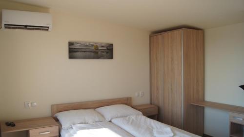 什图罗沃apartman Panorama的一间卧室配有一张床和一个木制橱柜