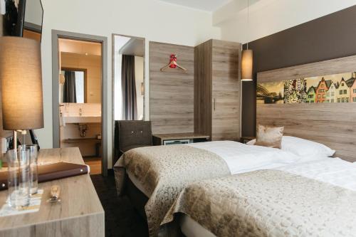 科隆锡安酒店的酒店客房配有两张床和一张书桌