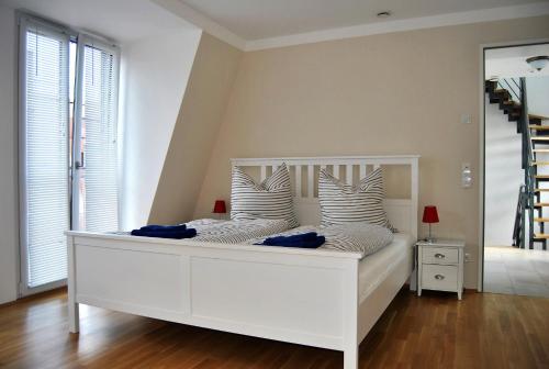 莱比锡特拉福德天空公寓的一张白色的床,位于带镜子的房间里