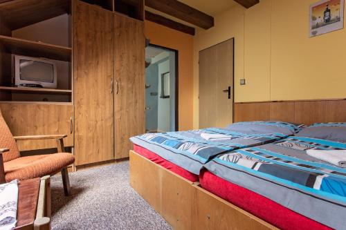 上贝奇瓦Chata Barborka的一间卧室配有一张大床和一把椅子