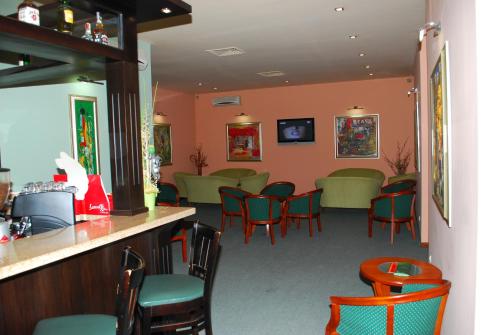 丘斯滕迪尔Hotel Velbazhd的一间设有绿色椅子和酒吧的等候室