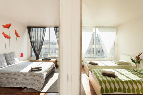 巴黎艾美公寓的一间卧室设有两张床和大窗户