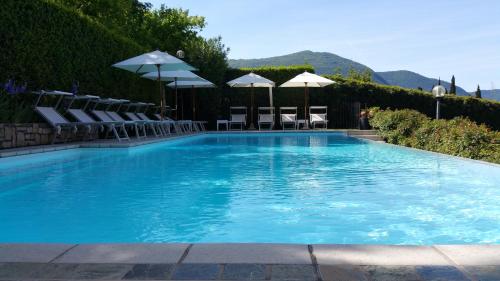 萨莱马拉西诺金希卡别墅酒店的一个带椅子和遮阳伞的大型蓝色游泳池