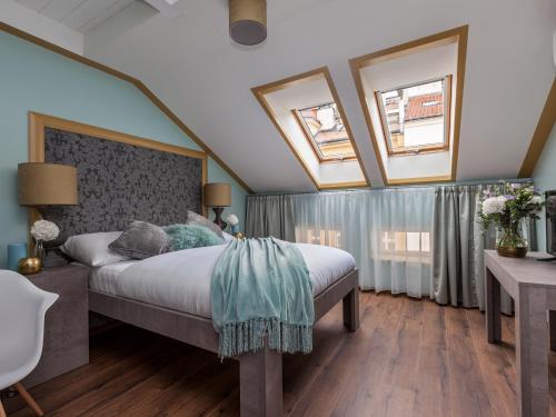 布拉格布拉格华丽酒店的一间卧室设有一张床和两个窗户。