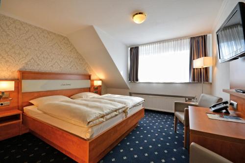 埃尔姆山麓克尼格斯卢特尔兰德宾馆&兰登豪斯酒店的配有一张床和一张书桌的酒店客房