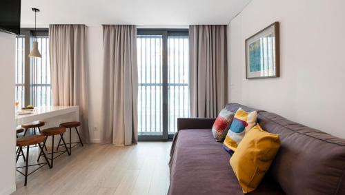 里斯本里斯本公园服务式公寓的一间带棕色沙发的客厅和一间厨房