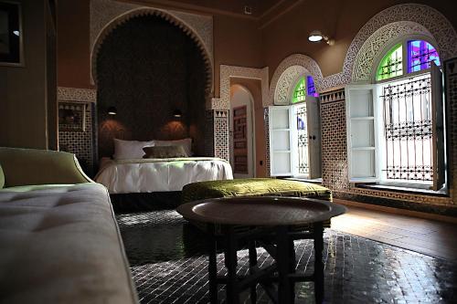 拉巴特阿尔卡萨酒店的一间卧室设有两张床、一张桌子和窗户。