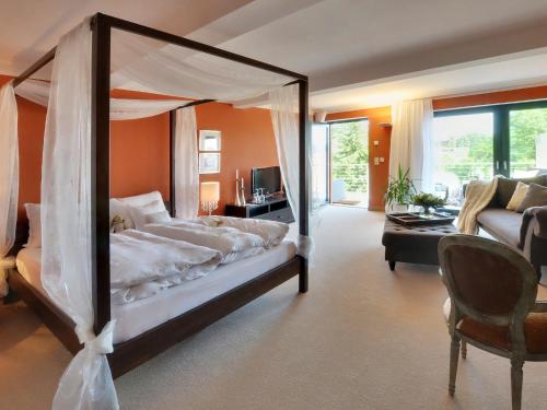 马尔肖罗森杜密兹酒店的一间带天蓬床的卧室和一间客厅