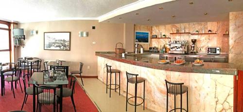 乌迪亚莱斯堡隆达酒店的餐厅设有酒吧、桌子和厨房
