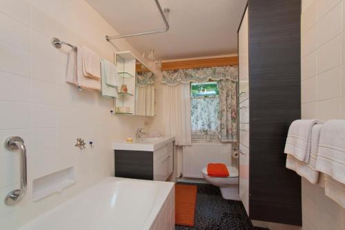 蒂罗尔州奥伯恩多夫Haus Waldrand的带浴缸、盥洗盆和卫生间的浴室