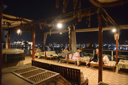 卢克索卢克索娜芙蒂蒂酒店的一群人晚上坐在阳台上