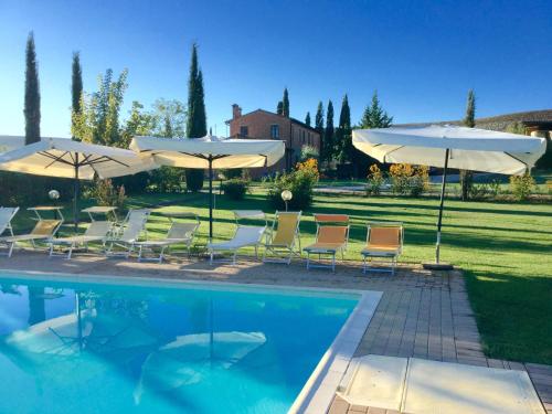 皮恩扎马瑞奈罗农场旅馆的游泳池旁设有椅子和遮阳伞
