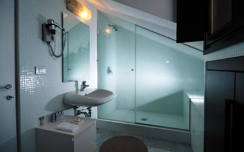 蒙扎第九酒店的一间带水槽和玻璃淋浴的浴室