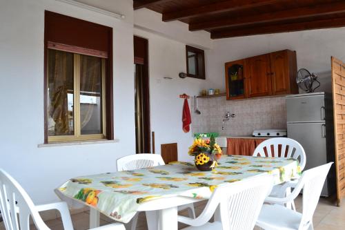 伊索拉戴里费米尼Casa Vacanze Laura的厨房配有桌子和白色椅子