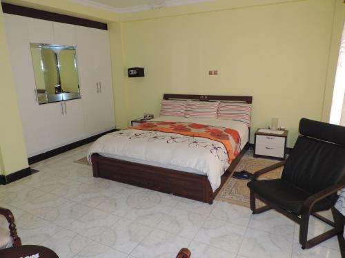 麦可乐Asimba Guest House的一间卧室配有一张床和一把椅子