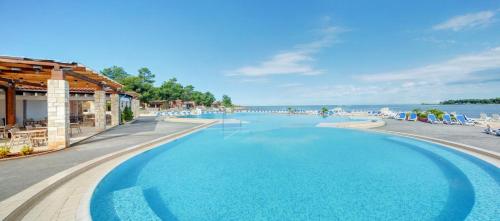 乌马格Apartments Stella Plava Laguna的享有水景的度假酒店的游泳池