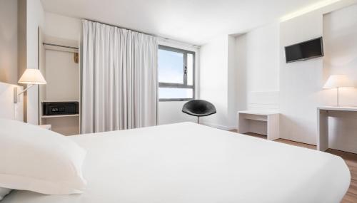 瓦伦西亚伊鲁尼昂瓦伦西亚3号酒店的白色的卧室设有一张大床和一个窗户