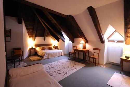 Saint-Cirgues-en-Montagne费朗迪拉克酒店的一间卧室设有床、两个窗户和一张沙发