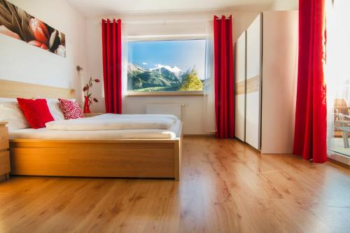 皮森多夫Oscar & Sons Apartments的一间卧室配有床和红色窗帘的窗户