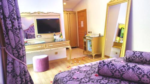 厄吕代尼兹Sundia By Liberty Oludeniz的客厅配有紫色沙发和电视