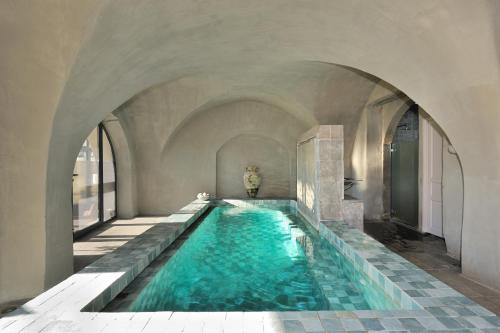 埃雷皮扬埃雷皮昂修道院酒店的一座带拱门的建筑中的游泳池